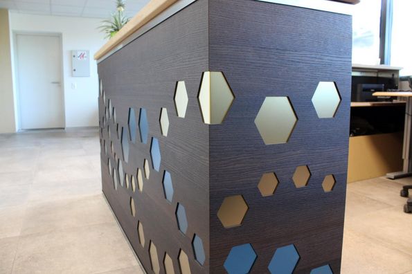 Referenzprojekt mit Furnier Express Fixmasse Structura Empfangstresen mit dunklem Strukturfurnier und heller Holzabdeckung