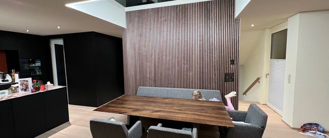 Akustikpaneele für hohe Räume – Referenz Wohnzimmer mit Nussbaum Lamellenwand Akustiklösung für hohe Räume