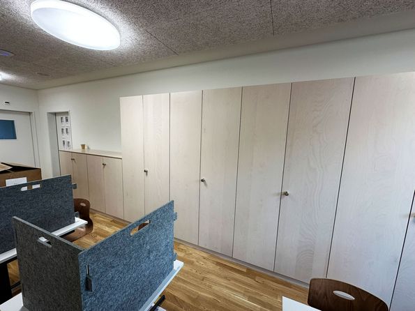 Helle Holzmöbel als warmer Kontrast zu Beton und Stahl im AHBasel